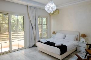 ein Schlafzimmer mit einem großen Bett und einem Kronleuchter in der Unterkunft New Cairo Escape2BR Apt I 8 min from Cairo Airport in Kairo + 27 Fotos