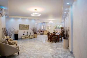 ein Wohnzimmer mit Tisch und Stühlen in der Unterkunft New Cairo Escape2BR Apt I 8 min from Cairo Airport in Kairo