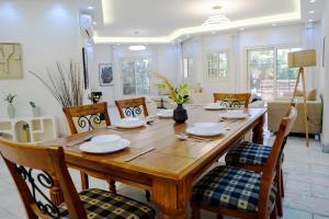 ein Esszimmer mit einem Holztisch und Stühlen in der Unterkunft New Cairo Escape2BR Apt I 8 min from Cairo Airport in Kairo