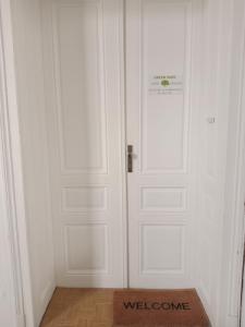 a white door with a welcome sign on it at Green Park Rooms Brno in Brno +44 photos