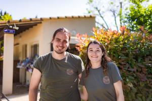 a man and a woman standing in front of a house at Camping Porte des Alpilles by M.A DESTINATION GLAMPING in Saint-Étienne-du-Grès