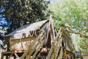 a tree house with a roof on top of it at Camping Porte des Alpilles by M.A DESTINATION GLAMPING in Saint-Étienne-du-Grès