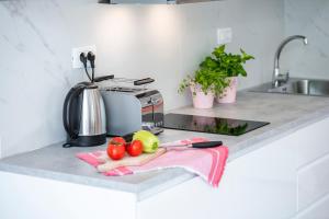 a kitchen counter with fruits and vegetables on a pink towel at Stylish sea view studio in Dubrovnik
