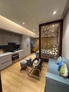 a living room with a blue couch and a kitchen at Vaelora Stay - Luxury Studio in Ghaziabad