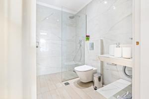 a white bathroom with a shower and a toilet at Hotel Selini in Agios Nikitas