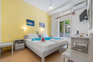 a bedroom with a bed and a desk in it at Hotel Selini in Agios Nikitas