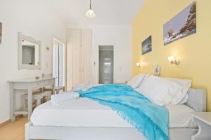 a bedroom with a bed with a blue blanket on it at Hotel Selini in Agios Nikitas