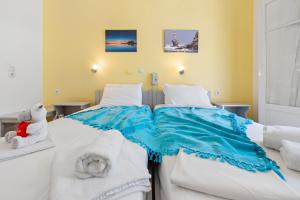 a bedroom with a large bed with blue and white sheets at Hotel Selini in Agios Nikitas