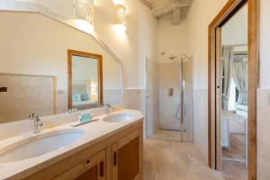 ein Badezimmer mit zwei Waschbecken und einer Dusche in der Unterkunft Menhir Boutique Apartments- Adult Only- by Obiettivo vacanza Budoni in Tanaunella + 80 Fotos