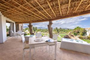 einen Tisch und Stühle auf einer Terrasse mit Aussicht in der Unterkunft Menhir Boutique Apartments- Adult Only- by Obiettivo vacanza Budoni in Tanaunella