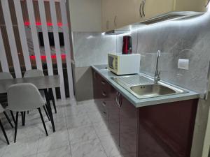 una piccola cucina con un lavello e un tavolo di Royal Harbor View Lux 4-Bedroom Waterfront Residence a Durrës