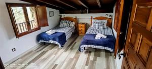 a bedroom with two beds and a window at Roble Viejo Rural House 