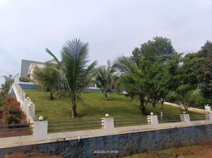 a park with palm trees and a fence at Cardamom Vista Homestay in Thekkady