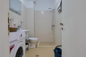 a bathroom with a toilet and a washing machine at Roses Apartment in Golem +11 photos