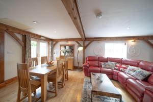 ein Wohnzimmer mit einem roten Ledersofa und einem Tisch in der Unterkunft 8 Bedroom, 6 Bath House, Large Patio, Large Parking in Hardwicke + 23 Fotos