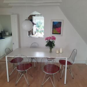 a dining room with a white table and chairs at Beautiful flat, 30 min away from central London in Bromley