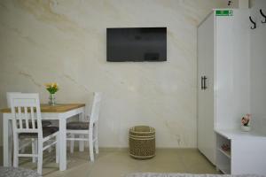 a dining room with a table and a tv on the wall at Apartmani kod kumašina in Kuršumlija