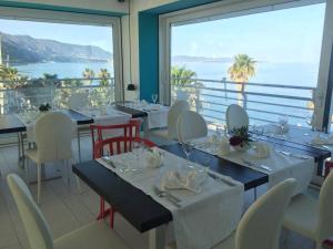 a restaurant with tables and chairs with a view of the ocean at Palma d'Oro in Bagnara Calabra
