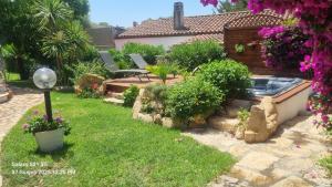 a garden with a swimming pool and flowers at Betty vacanze in Badesi