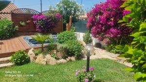 a garden with flowers and a lamp in the grass at Betty vacanze in Badesi