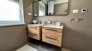 une salle de bain avec un lavabo et un miroir dans l'établissement AP Residence Contessa, à Bužinija 58 autres photos