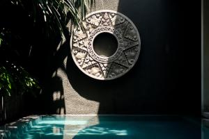 a plate on a wall next to a swimming pool at Blossom Eco Luxe Villas by Ekosistem in Canggu