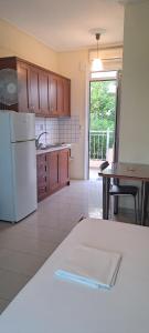a kitchen with a white refrigerator and a table at Golden Sun Apartments in Rovies