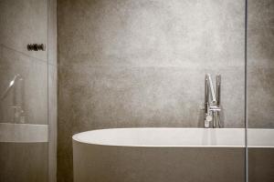 a bathroom with a bath tub and a shower at Blossom Eco Luxe Villas by Ekosistem in Canggu