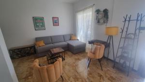 a living room with a couch and chairs in it at Wildflowers House - JApartments in Genova