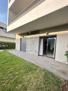a house with a wooden walkway next to a yard at Logement luxueux avec 2 piscines in Dar Hamida +3 photos