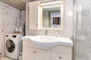 Un baño con lavabo y lavadora. en Cozy apartment - new kitchen - city center by the Royal Palace, en Oslo