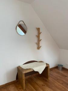 Una habitación con un banco y un espejo en la pared. en Chambre campagne et salle de bain privée, en Le Mesnil-Guillaume 8 fotos más