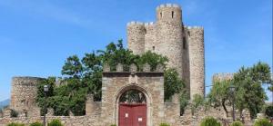 a castle with a red door and a tower at TU ESPACIO:Confort y Diversión. in San Martín de Valdeiglesias