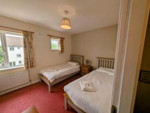 a bedroom with two beds and a window at Large 4 Bedroom 5 Bathroom Property in Galway +4 photos