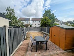 a patio with a table and chairs and a fence at Large 4 Bedroom 5 Bathroom Property in Galway