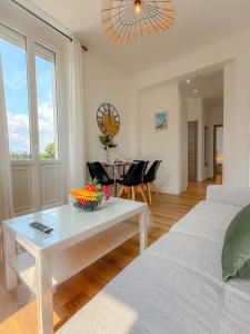 a living room with a white couch and a table at Le Margot By ApiRent #Climatisation #Wifi #Balcon in Cannes