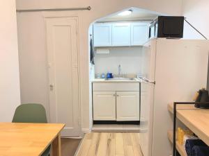 een kleine keuken met een spoelbak en een koelkast bij Chelsea Studio-Shared Bathroom with Kitchen Twin Bunk Bed in New York