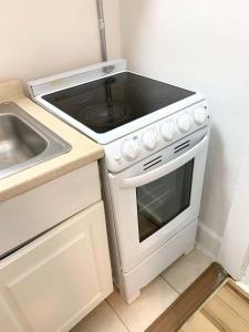 een keuken met een fornuis bovenoven naast een gootsteen bij Chelsea Studio-Shared Bathroom with Kitchen Twin Bunk Bed in New York