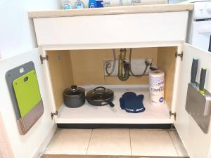 een keukenkastje met potten en pannen en een gootsteen bij Chelsea Studio-Shared Bathroom with Kitchen Twin Bunk Bed in New York +8 foto's