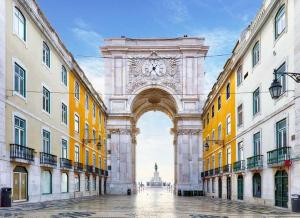 a large arch with a clock in the middle of two buildings at Santa Justa Cozy Room in Lisbon
