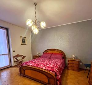 a bedroom with a bed and a chandelier at LA PANORAMICA Svegliati con la Vista delle Alpi dalle Camere e Terrazza Ampia in Berzo