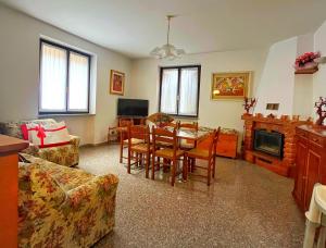 a living room with a table and chairs and a fireplace at LA PANORAMICA Svegliati con la Vista delle Alpi dalle Camere e Terrazza Ampia in Berzo
