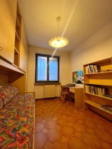 a bedroom with a bed and a desk and a window at La Casa Panoramica in Berzo