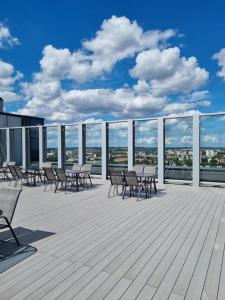 una terrazza con sedie e tavoli su un edificio di JBHotels Apartament Deluxe Hanza Tower a Stettino 1 altra foto