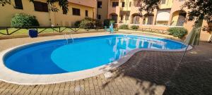 a large blue swimming pool in a courtyard at Perla Apartment con vista mare in Olbia