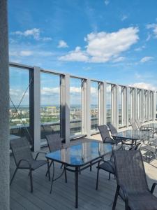 un balcone con tavoli e sedie in un edificio di JBHotels Apartament Deluxe Hanza Tower a Stettino
