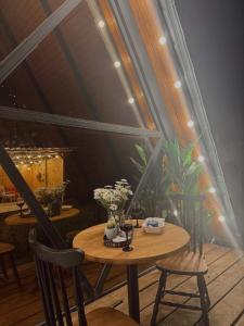 a wooden table with chairs and flowers on it at Cottage Milu კოტეჯი მილუ in Kutaisi +9 photos