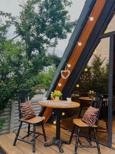 a table and two chairs on a wooden deck at Cottage Milu კოტეჯი მილუ in Kutaisi