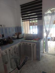 una cucina con un lavandino e una finestra di Studio de la plage d'Albion a Mauritius