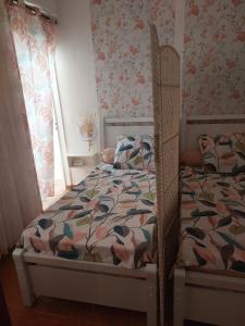 una camera da letto con un letto con un piumone e una finestra di Studio de la plage d'Albion a Mauritius